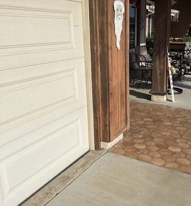 A white garage door featuring a sign affixed to its surface, indicating its purpose or ownership.
