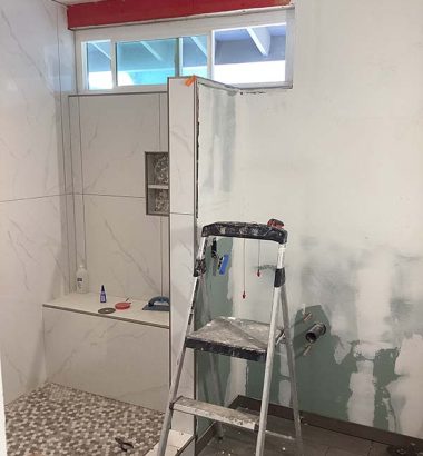A bathroom featuring a ladder and a shower, showcasing a unique design element in the space.