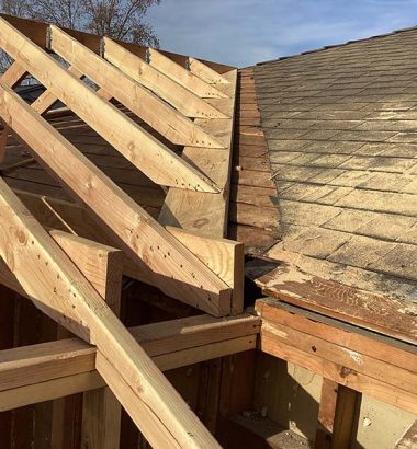 A construction site showing wooden trusses being assembled for a roof.