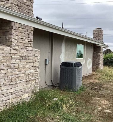 A house featuring a brick chimney and a single window on the front facade.