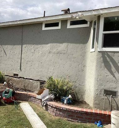 A house featuring a brick wall and a matching brick patio, showcasing a cohesive architectural design.
