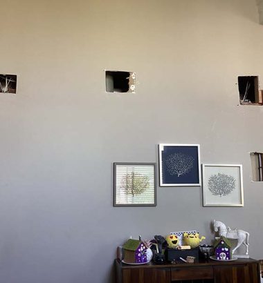 Living room featuring holes in the ceiling and framed pictures hanging on the walls.