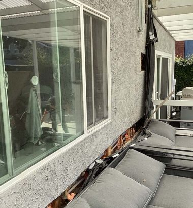 A cozy patio featuring a comfortable couch and a large window, inviting relaxation and outdoor views.