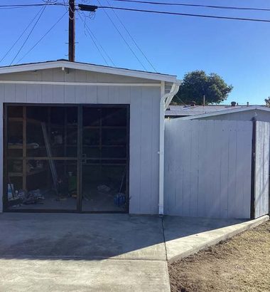 A garage with an open door and a car parked in the driveway.
